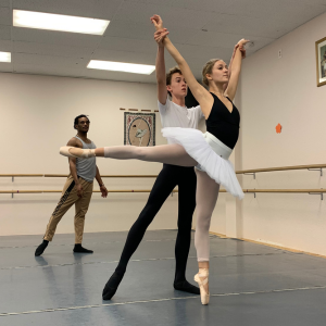 Pre-professional students being coached for pas de deux by a professional male teacher