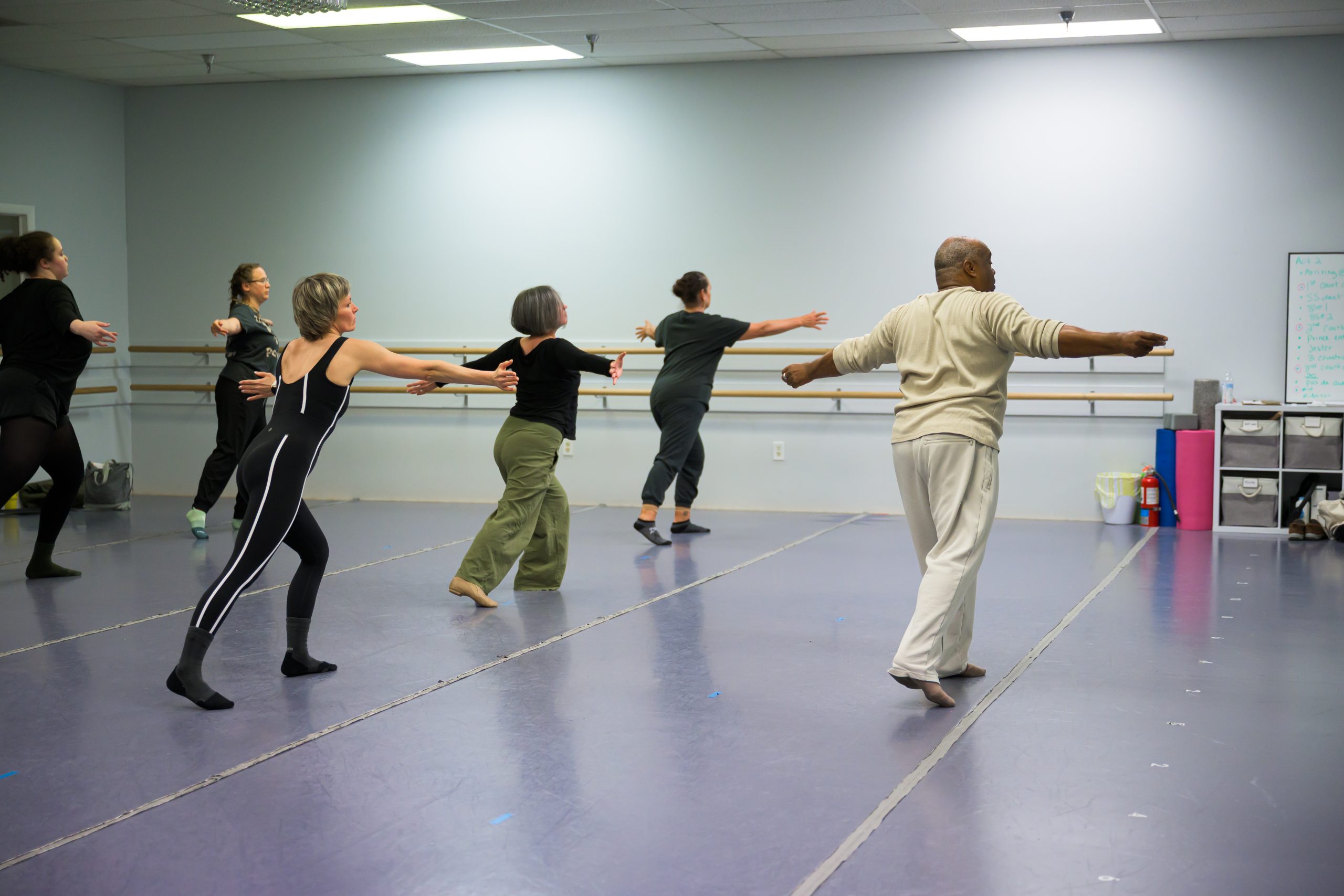 Adult dance students at the ballet barre during an intro to ballet class.