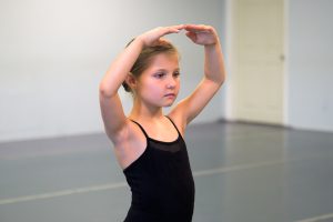 A ballet level 1 student working on her balance in ballet class.