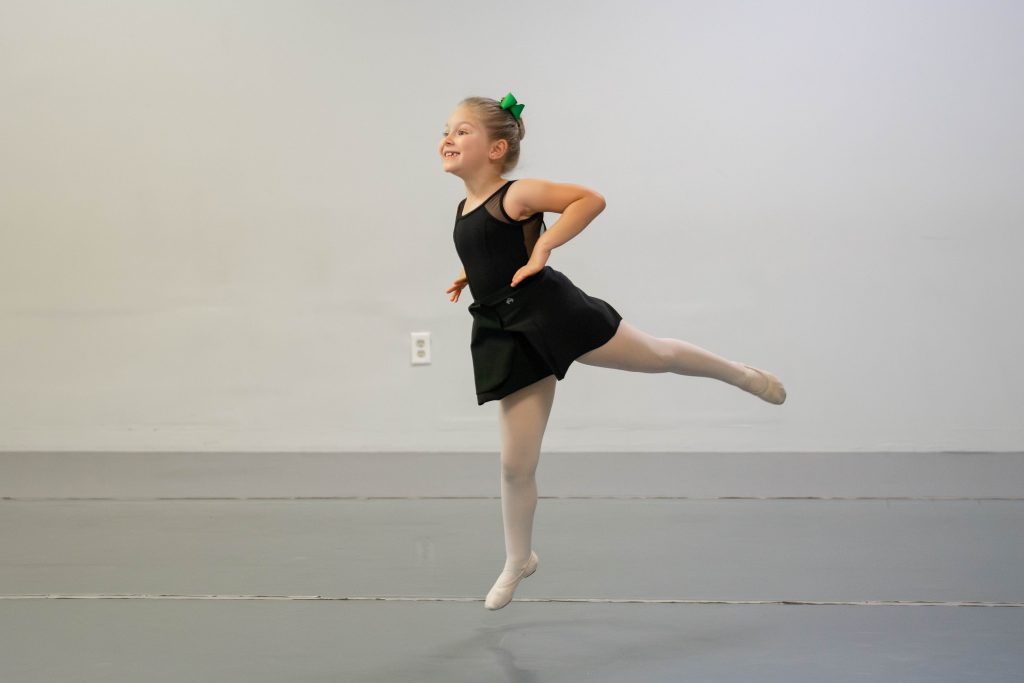 Level 1 ballet student doing a sauté arabesque across the floor.  This step is fun and exciting while also building coordination and strength.