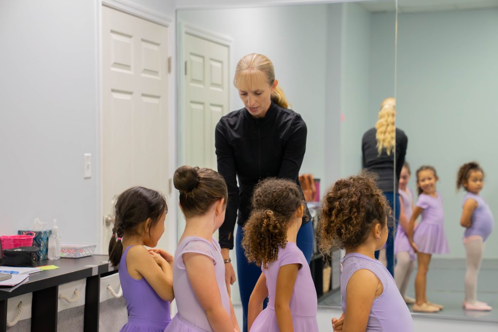 Mrs. Heidi's pre-ballet 5 class in line ready to dance across the floor. This is the part of class where they learn traveling steps which are fun but also teach them coordination and direction of movements (forward or side).